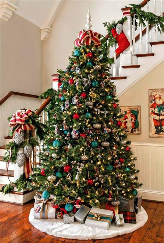 Podoba božičnega drevesa z okrasom iz rdečih in modrih srebrnih kroglic ter okrasjem iz svetlega venca iz rdeče in bež rube