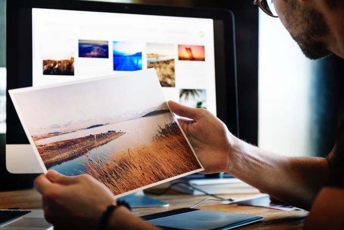 güzel ve huzurlu bir doğal manzarayı temsil eden bir fotoğraf baskısı tutan bir adam, çeşitli boyutlarda fotoğraf posterleri ile duvar dekorasyon fikirleri