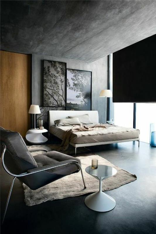 modernus arba pramoninis miegamasis, ant sienų melsvai pilki dažai, kontrastingos šviesiai medinės durys, šviesiai smėlio spalvos kilimas, akcento spalva su pilkomis sienomis