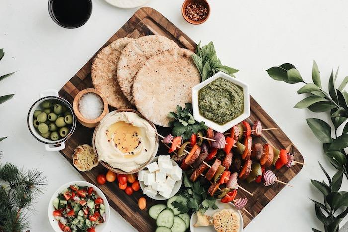 Spiedini di verdure, piadine di pane integrale, ciotole con olive, cena leggera invernale