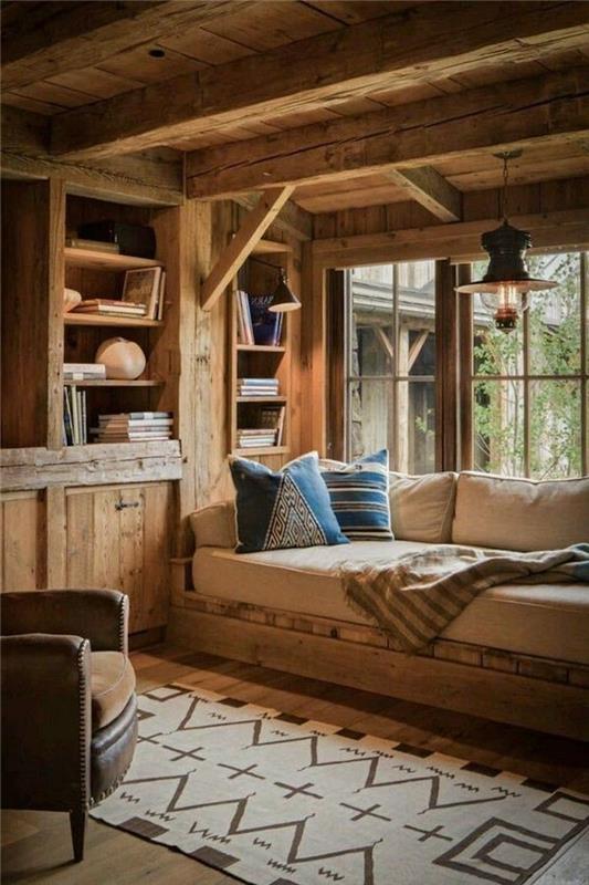 Kavč pod oknom, geometrijska preproga, majhna lesena koča, dekoracija gorske koče, ideja za dekoracijo