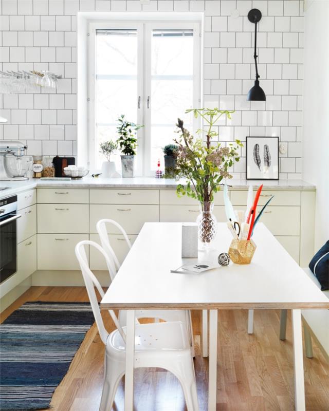 Skandinavsko pohištvo, stenska obloga iz bele opeke, šopek zelenega cvetja na beli mizi
