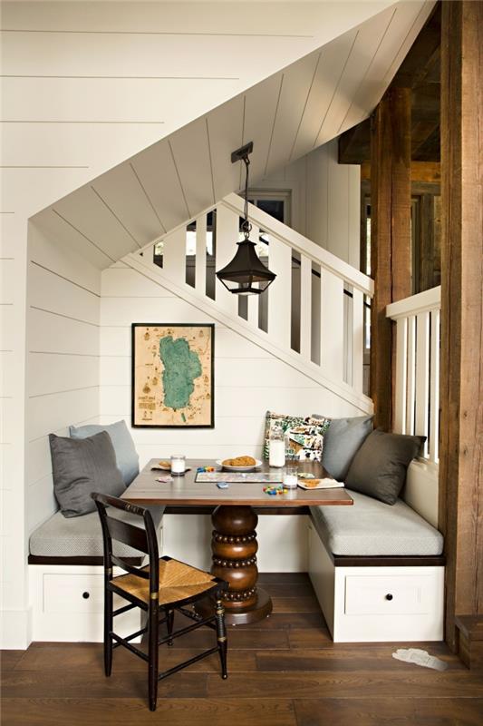 merdiven altı mobilya montajı koyu ahşap tezgah açık gri örtü dekoratif minderler koyu ahşap masa