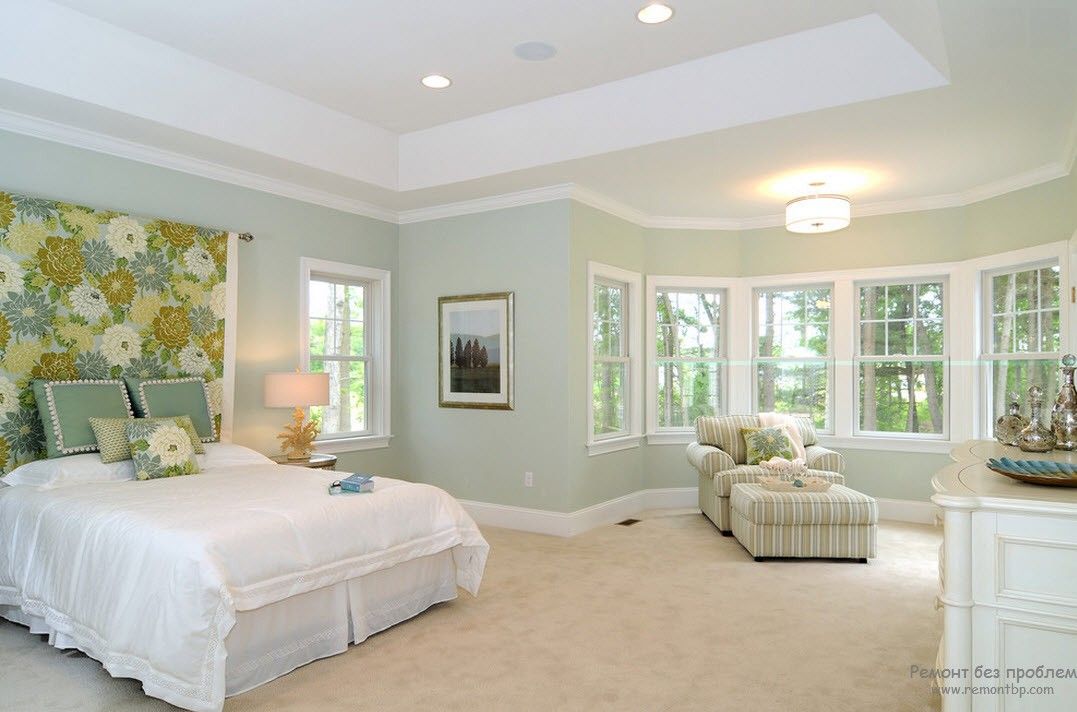 Luminosa camera da letto con mobili bianchi con accenti oliva e senape