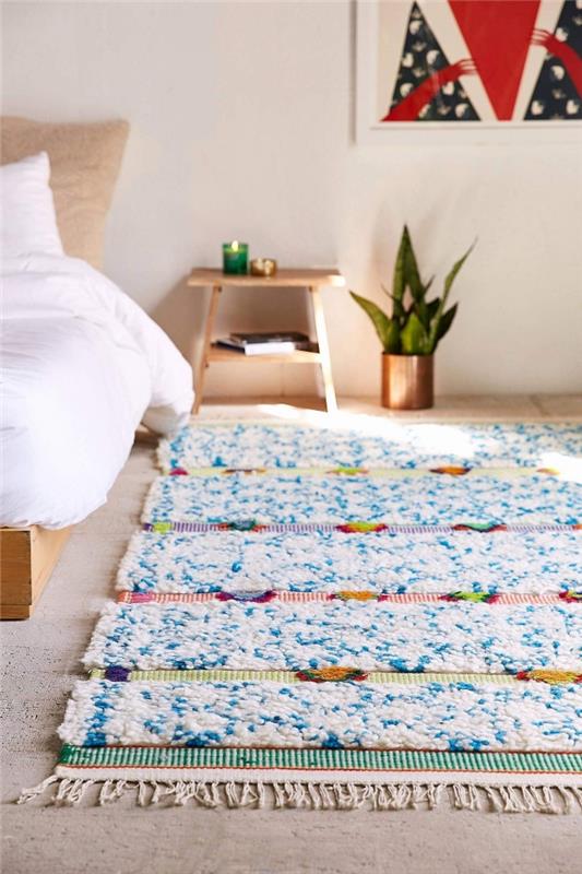 Ahşap mobilya ve yeşil bitki ile modern ve rahatlatıcı tarzda genç yatak odası düzeni, saçak dekorasyonu ile yumuşak halı deseni