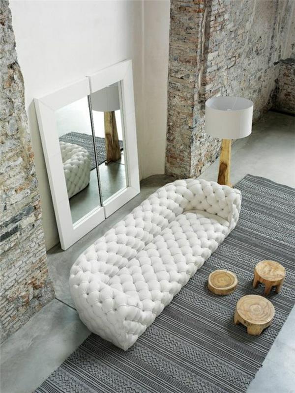 interjeras-svetainė-su akmeninėmis sienomis-minkšta sofa-balta-balta-oda-pilka, pakeisto dydžio kilimas
