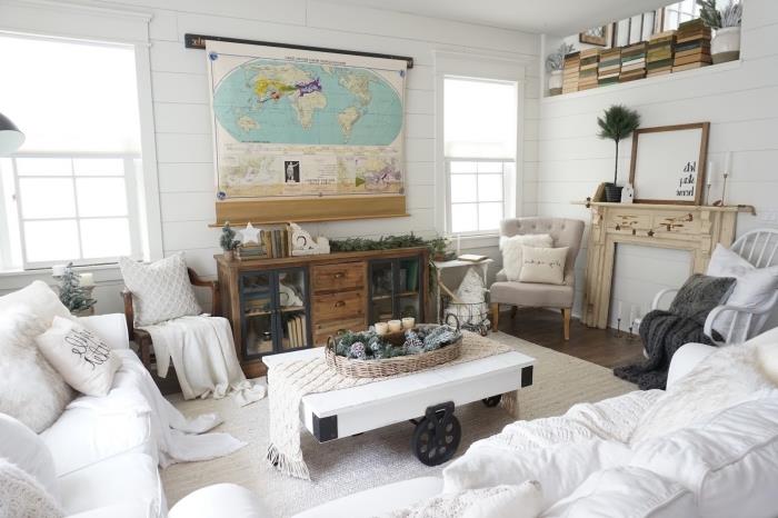 kokoniškas baltas svetainės dekoras su didele minkšta balta sofa ir pramoniniais baldais autentiškai ir jaukiai atmosferai