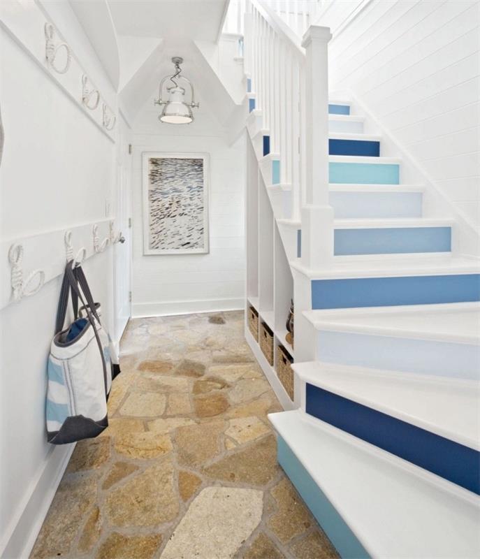 belo stopnišče z dvižnimi stopnicami, pobarvanimi v odtenkih modre in bele obložene stene za vzdušje počitniške hiše, prenovite leseno stopnišče z barvanjem stopnic in dvižnih stopnic v kontrastnih barvah