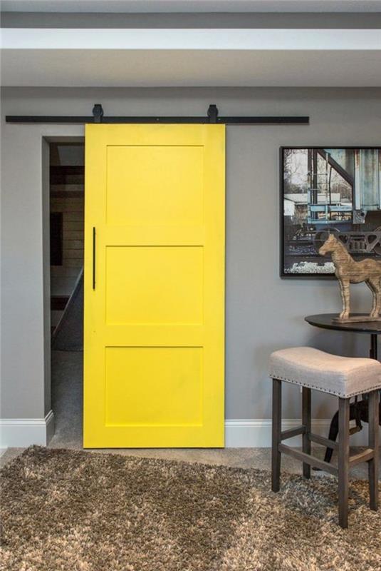 pilkas-interjeras-geltonas-tvartas-durys-jaukus-kilimas