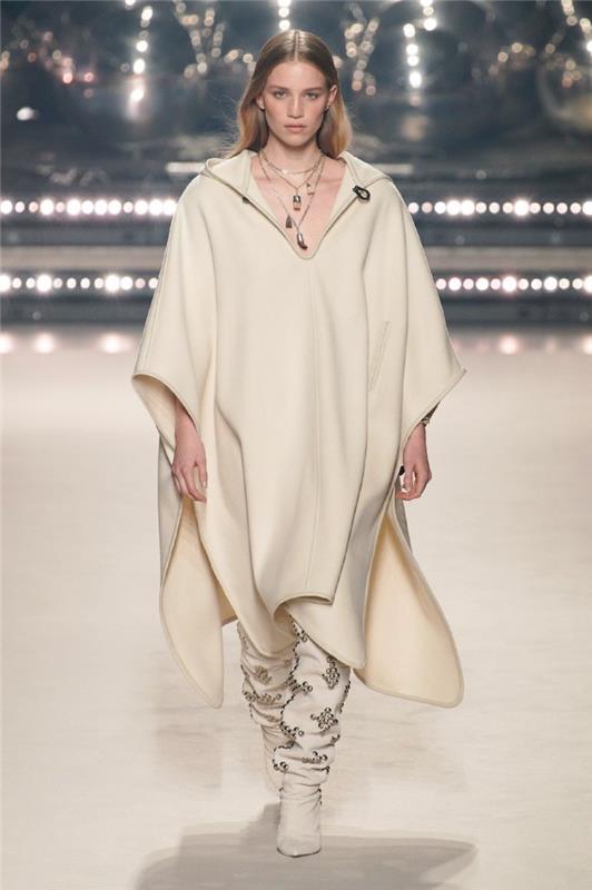 Isabel Marant žiemos tendencija 2021 m. tamsiai baltos spalvos pončo su batais ir ekstravagantiška apykakle