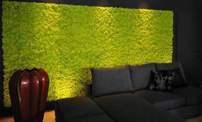 vidaus apdaila su žalia putų plokšte, juoda sofa, dekoratyvinės pagalvėlės