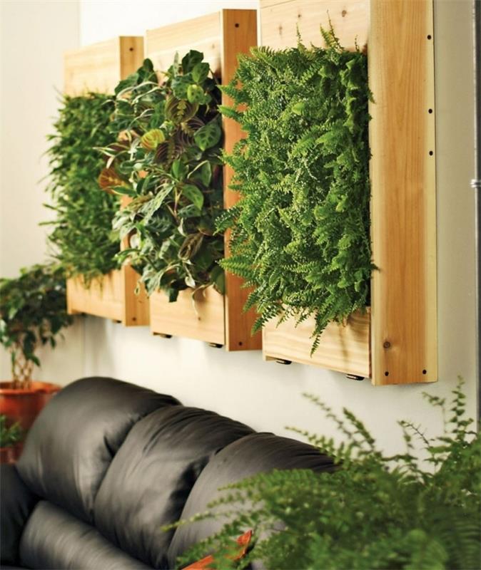 didelė juoda sofa, žalia siena, sudaryta iš trijų rėmų, gyva apdaila