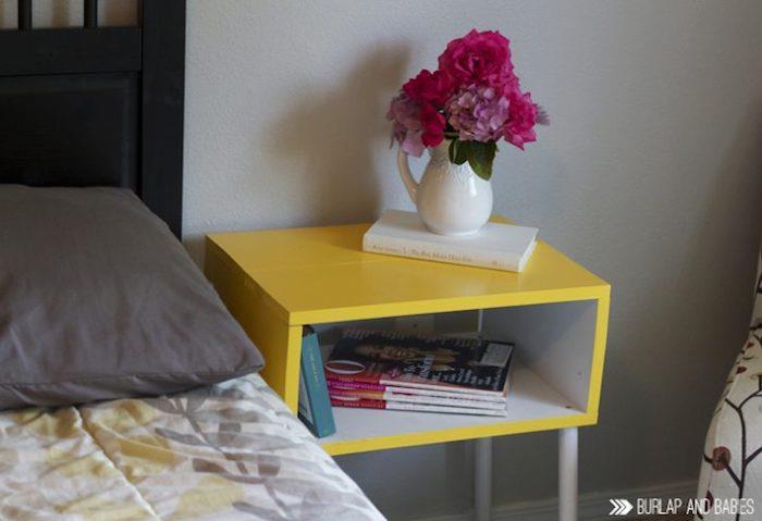 Geltonas naktinis stalas, papuoštas vaza su gėlėmis, tapybos idėja virtuvės spintelei, perdažyta spalvota medinė spintelė