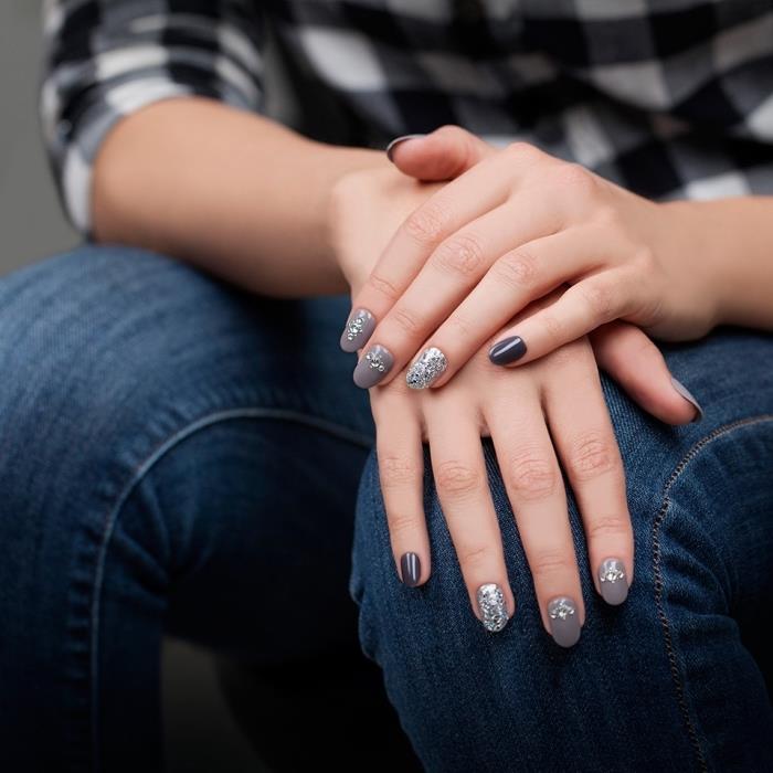 gel model nohtov sivih odtenkov s srebrno bleščečo dekoracijo, nail art z okrasnimi kamenčki na sivi podlagi