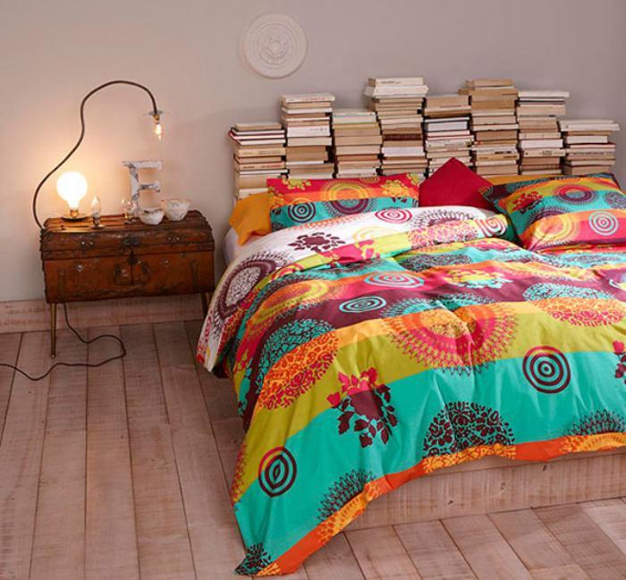 įvairiaspalvės lovos metimo medinės grindys ir galvūgalis su knygomis