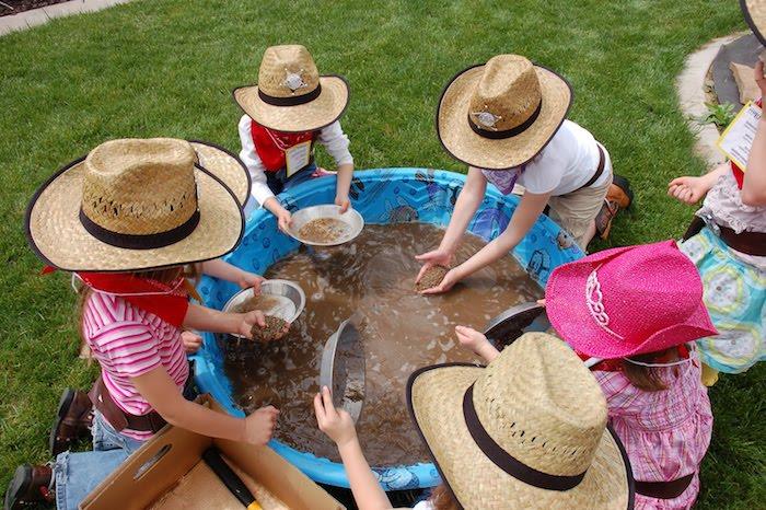 Batıdan ilham alan bir oyun için orijinal fikir, altın avı, şişme çamur havuzunda altın için balık tutan kovboy gibi giyinmiş çocuklar