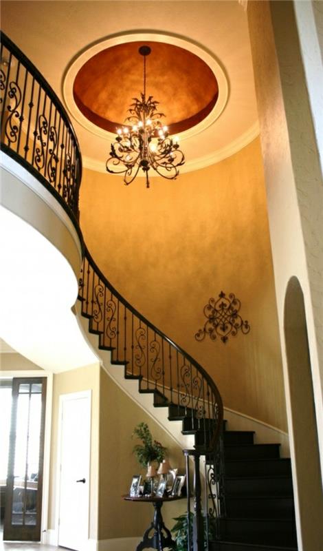 gana pusiau apsisukę laiptai-smėlio spalvos lubos ir baroko liustra iš geležies spiralinių laiptų