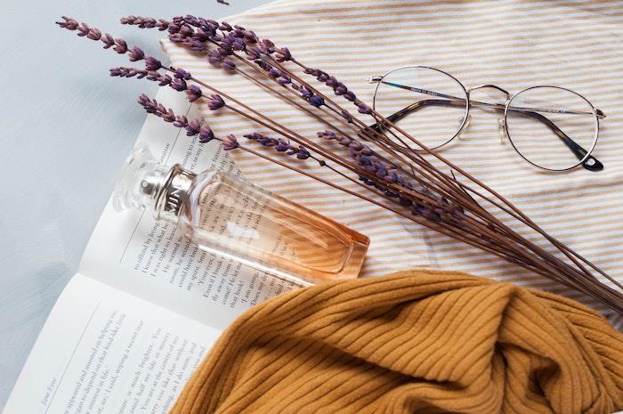 açık bir kitap hipi gözlük üzerinde döşeme güzel cam parfüm şişesi