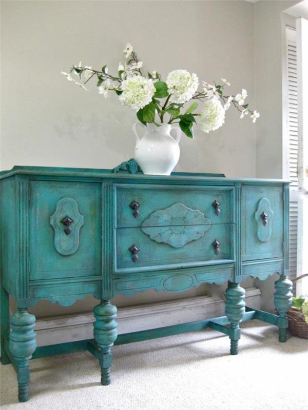 gana retro-prašmatnūs baldai tamsiai mėlynos spalvos ir gėlės ant medinės komodos, atnaujinami mediniai baldai