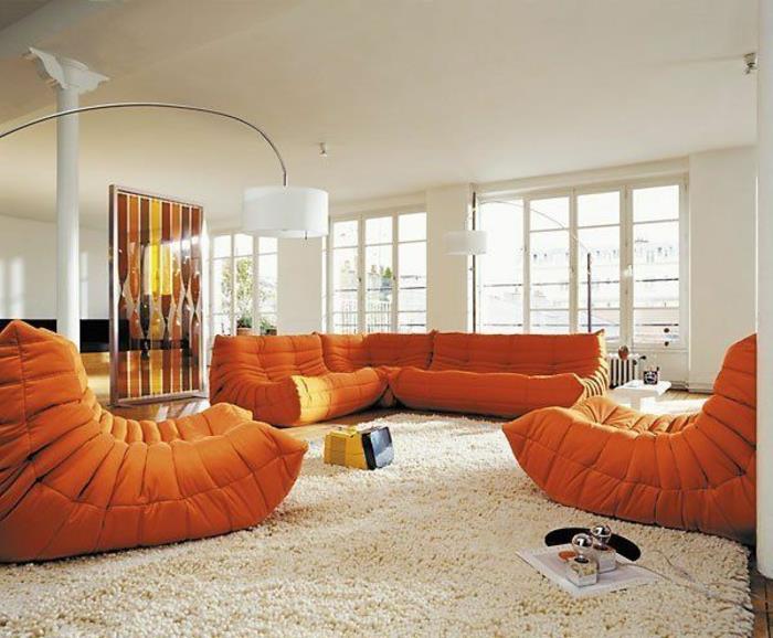 graži svetainė su baltu kilimu ir baldais, papuošalais smėlio spalvos sienomis ir lubomis lanko formos svetainės šviestuvas
