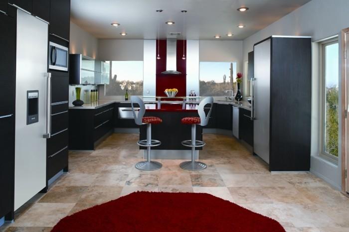 graži virtuvė-juodi baldai ir apvalus raudonas kilimas virtuvei