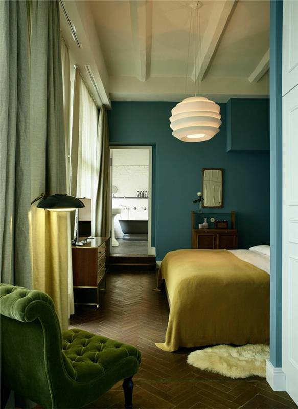 modra stena, bela stropna svetilka, vintage zelen naslanjač, ​​parket chevron, modra stenska barva