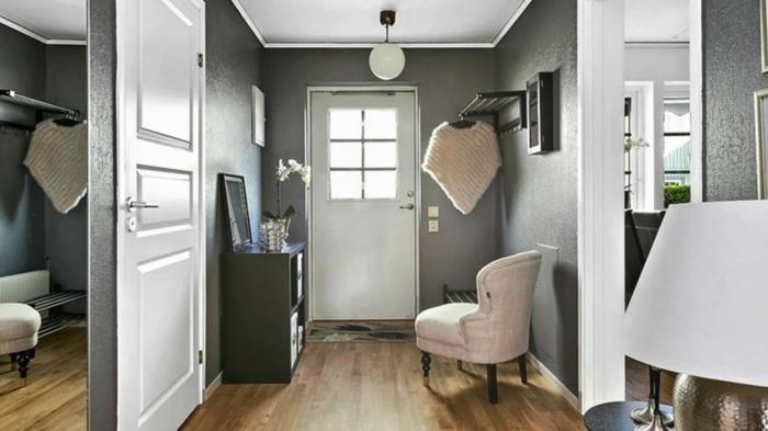 buto ar namo įėjimo apdaila, medinės grindys, balta kėdė, juoda konsolė, didelis veidrodis prie sienos