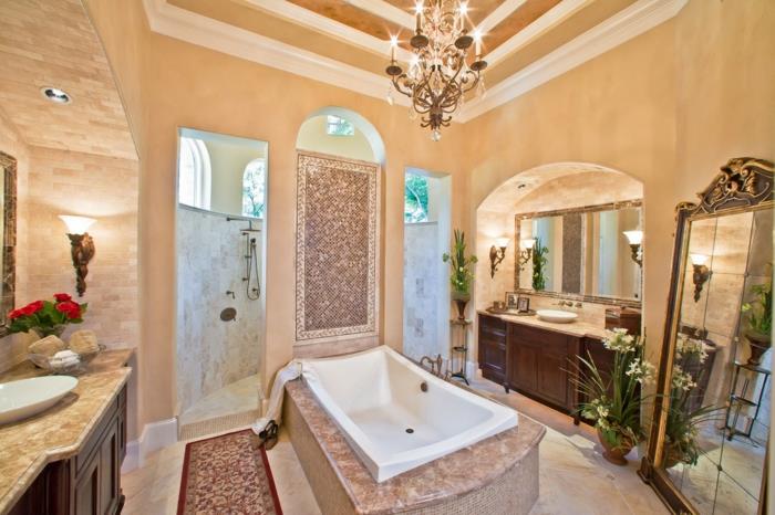 gražus vonios kambarys su smėlio spalvos interjeru ir baltas vonia su kilimu vonios kambaryje