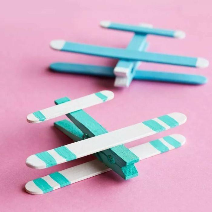 Basit mavi renkli ahşap bir uçak yapmak için mandal ve dondurma çubukları, çocuk için birincil manuel aktivite