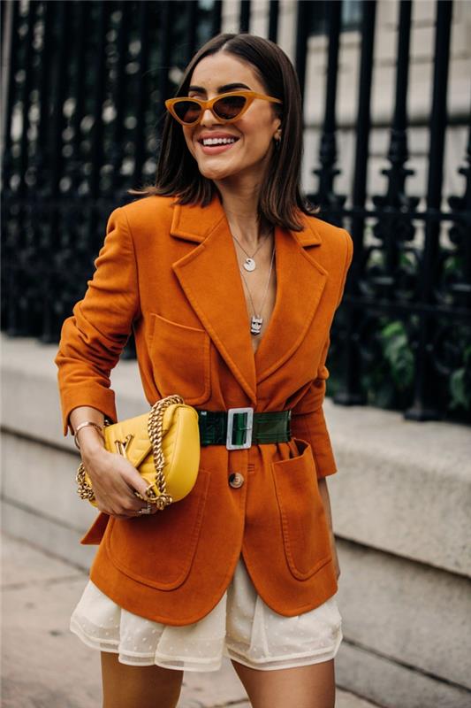 moteriškas kryžminis krepšys, oranžinė zomšos striukė, oranžinio rėmo saulės akiniai, baltas mini sijonas
