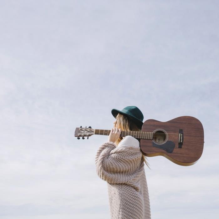 Uzun tıknaz örgü hırka, gitarlı bohem şık kadın görünümü, sonbaharda bohem şık, soğukta nasıl giyinileceğine dair fikir