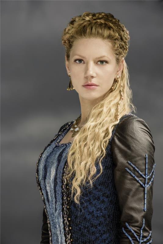 vikings lagertha, mavi elbise, siyah deri kollar, doğal makyaj, altın küpeler, kıvırcık saç örgüsü