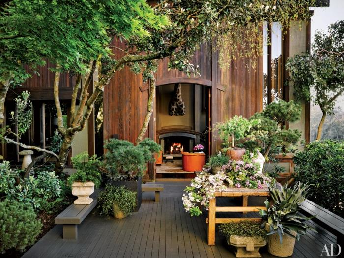 Medinio namo išorinė apdaila, medinės terasos apželdinimo kampas gerai apželdinti medžiai ir žali augalai