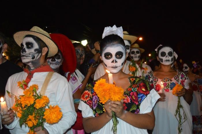 Meksika'da ölülerin günü, parti için giyinmiş Meksikalılar, sarı buketler, yanan mumlar ve kuru kafa makyajı