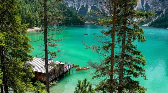 kalnuoto kraštovaizdžio nuotrauka su ežeru su turkio spalvos vandeniu ir spygliuočių medžiais, gražūs tapetai su kalnais