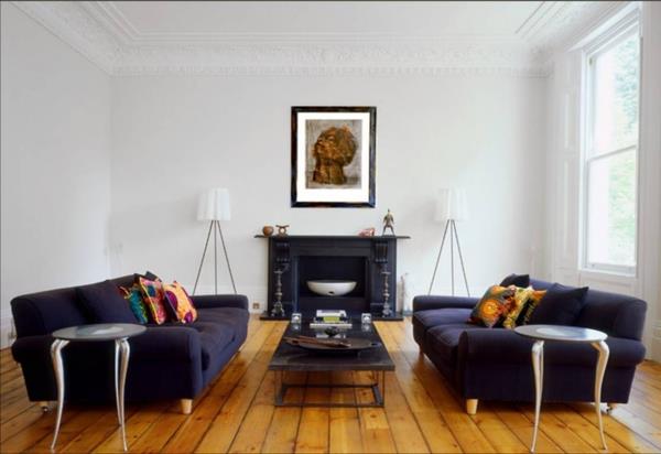 grindų lempa-trikojis-jaukios sofos ir medinės grindys