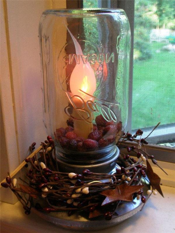 „pasidaryk pats“ stalinė lempa, pagaminta iš perdirbto stiklo indelio, metalinės atramos ir švino žvakės