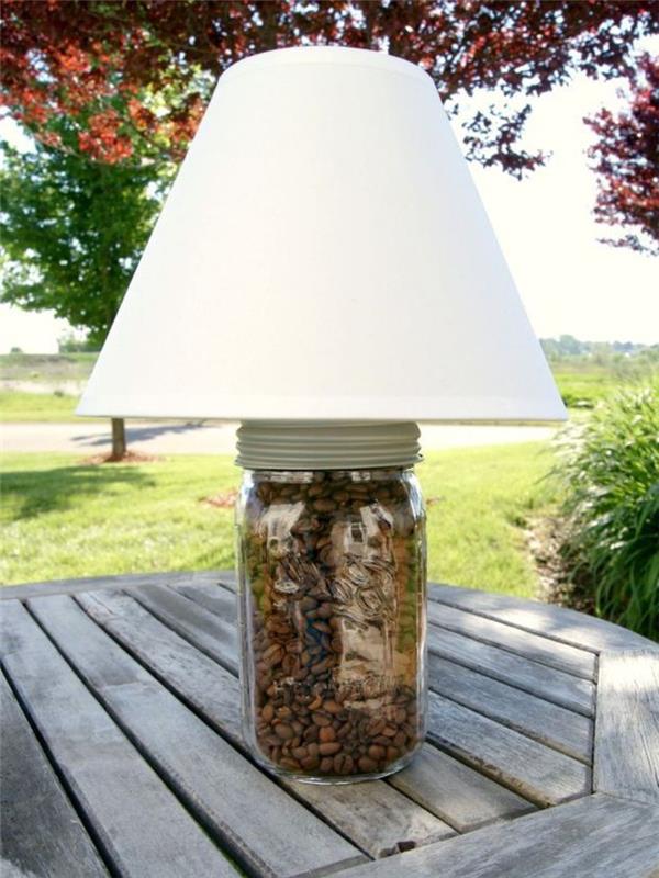 „pasidaryk pats“ originalus lempos prie lovos projektas, pagamintas iš perdirbto stiklo indelio, pilno kavos sėklų ir klasikinio dizaino abažūrio