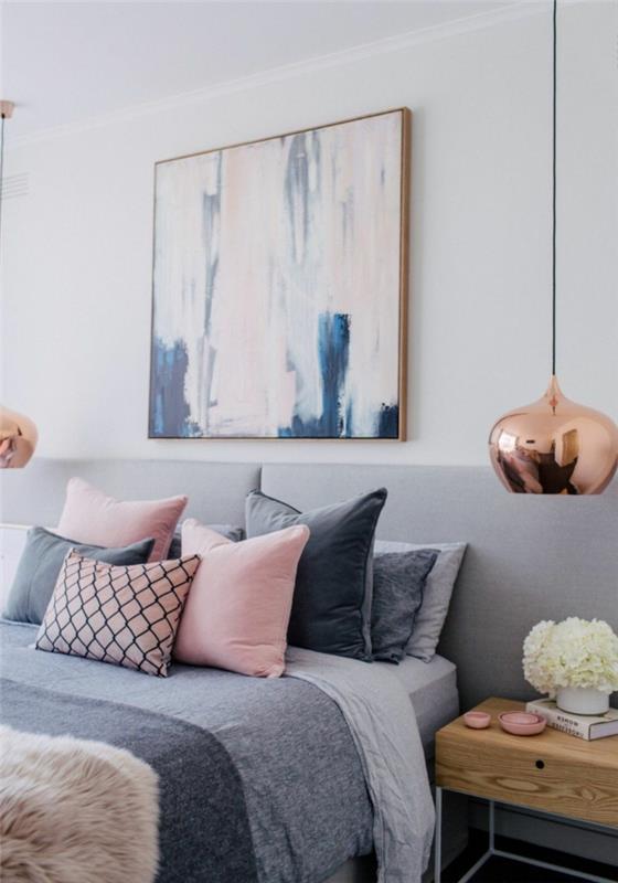 „cocooning deco“, rožinės ir pilkos spalvos pagalvėlės, abstrakti tapyba, dvi pakabinamos lempos vario spalvos, medinis naktinis stalas