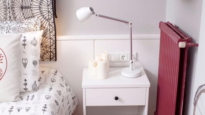 boemski eleganten dekor v sodobni spalnici z belimi stenami z belim lesenim pohištvom, modelom okrasnih blazin v beli in črni barvi s simboličnimi vzorci