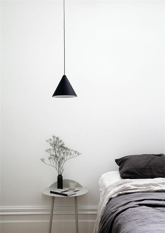 minimalist dekora sahip tek renkli bir yatak odası, konik şekilli minimalist bir başucu sarkıt lamba