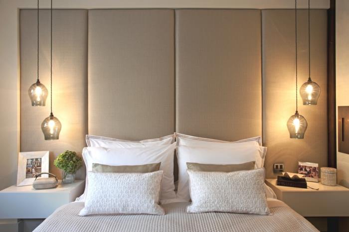 uyumlu dekora sahip nötr tonlarda bir yatak odası, yatağın her iki tarafında alçak cam sarkıt lamba