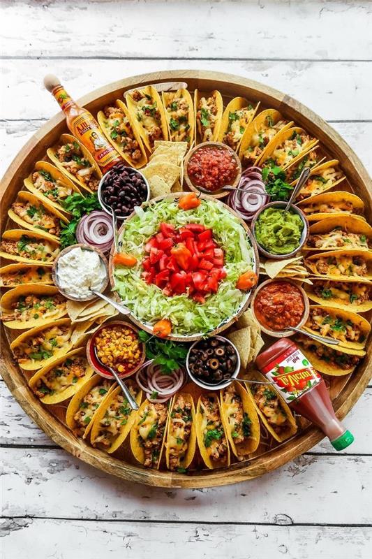 mini tacos, išdėstytos ant didelio medinio padėklo, stikliniai dubenys, užpildyti įvairiais ingredientais, maltos jautienos taco receptas