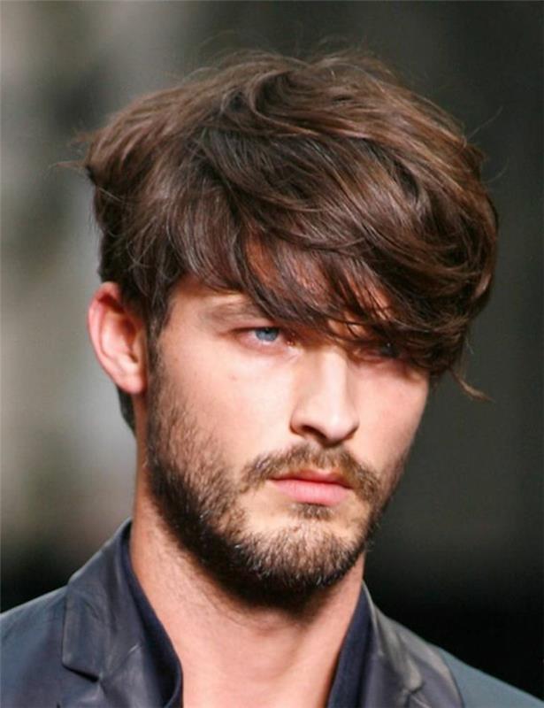 šiške, ki padajo na eno oko, rjavolaska tekstura in večplastna frizura, ki jo nosi modrooki moški, s kratko brado in brki