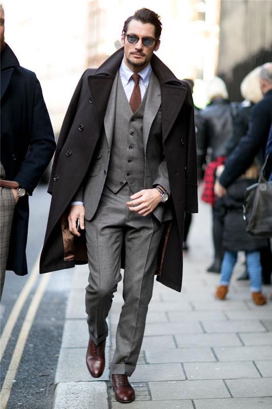 Ilgas juodas paltas, pilkas trijų dalių kostiumas, šviesiai mėlyni marškiniai, rudas kaklaraištis, kaip gerai apsirengti, elegantiška kasdieninė vyriška apranga