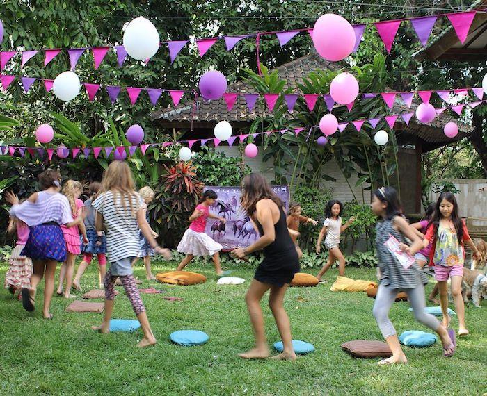 çocuklarla dışarıda çimenlerin üzerinde müzikli yastık, flamalar ve renkli balonlarla doğum günü dekorasyonu, 9 yıl doğum günü