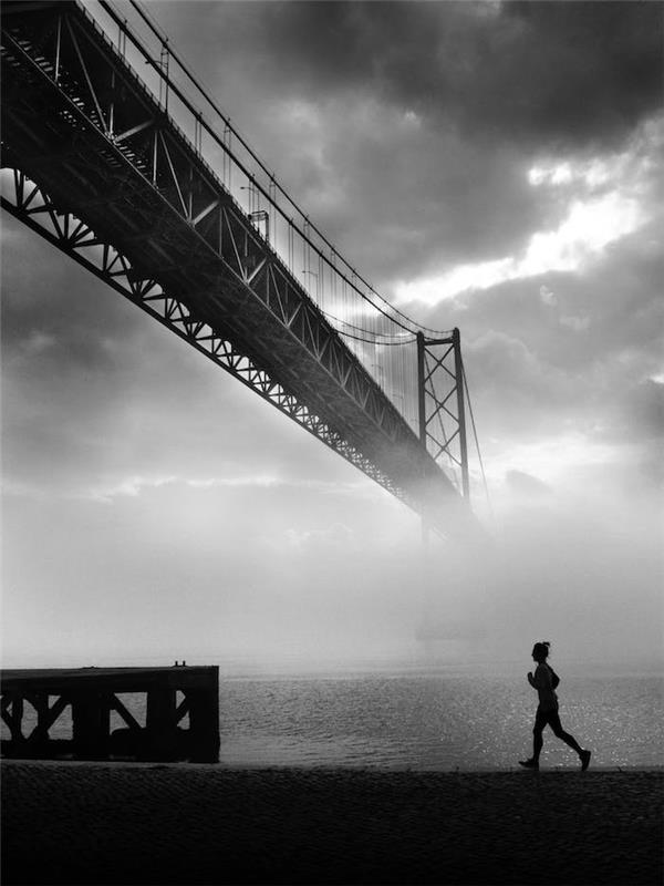 Rdeči most v San Franciscu v črno -belem temnem ozadju tekaška ženska, črno -bela umetniška fotografija, ozadje Nike