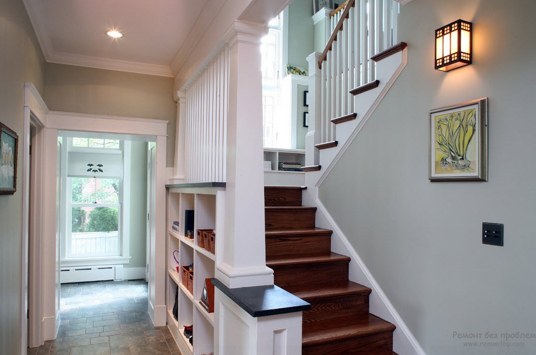 Koridorda merdivenli beyaz bir iç mekan tasarımı, alanı görsel olarak daha parlak hale getirir.