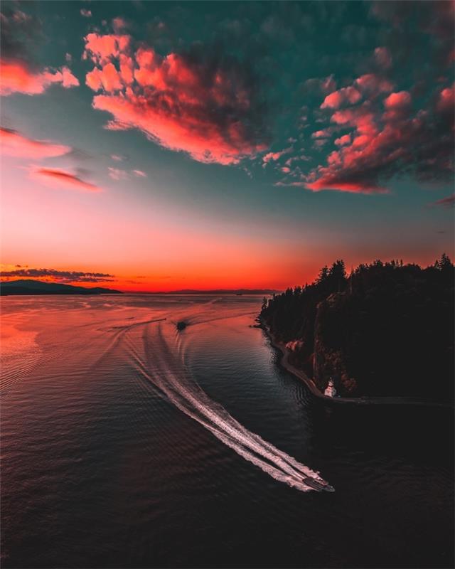 nemokamų tapetų pavyzdys, graži gamtos nuotrauka su valtimi ant vandens, nuspalvinta saulėlydžio