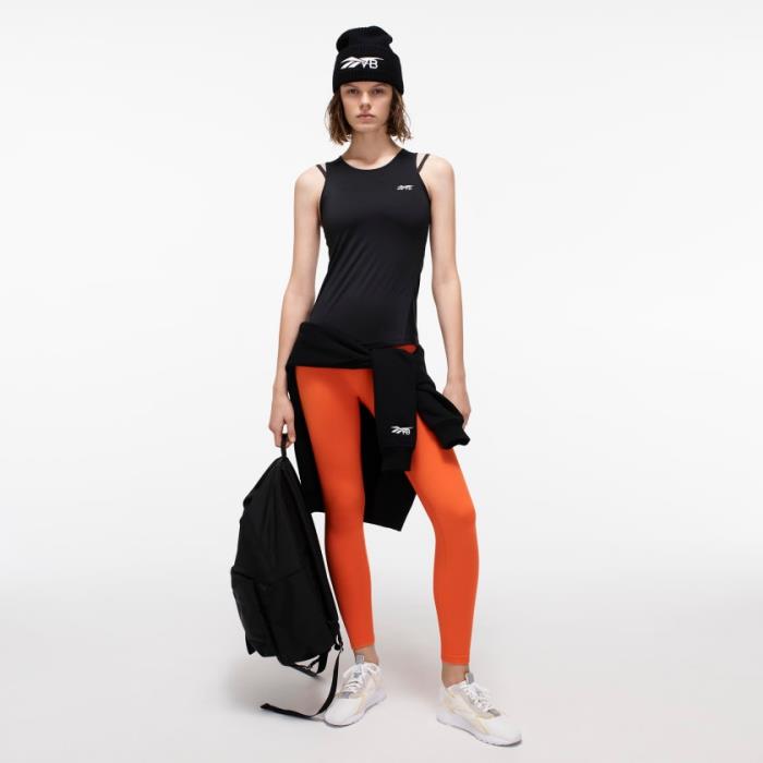 idėja sportinė kepurė juodos spalvos, juodas moterų viršus, antblauzdžiai oranžinės spalvos, juoda unisex rankinė iš „Reebok“ ir „Victoria Bechkam“ kolekcijos